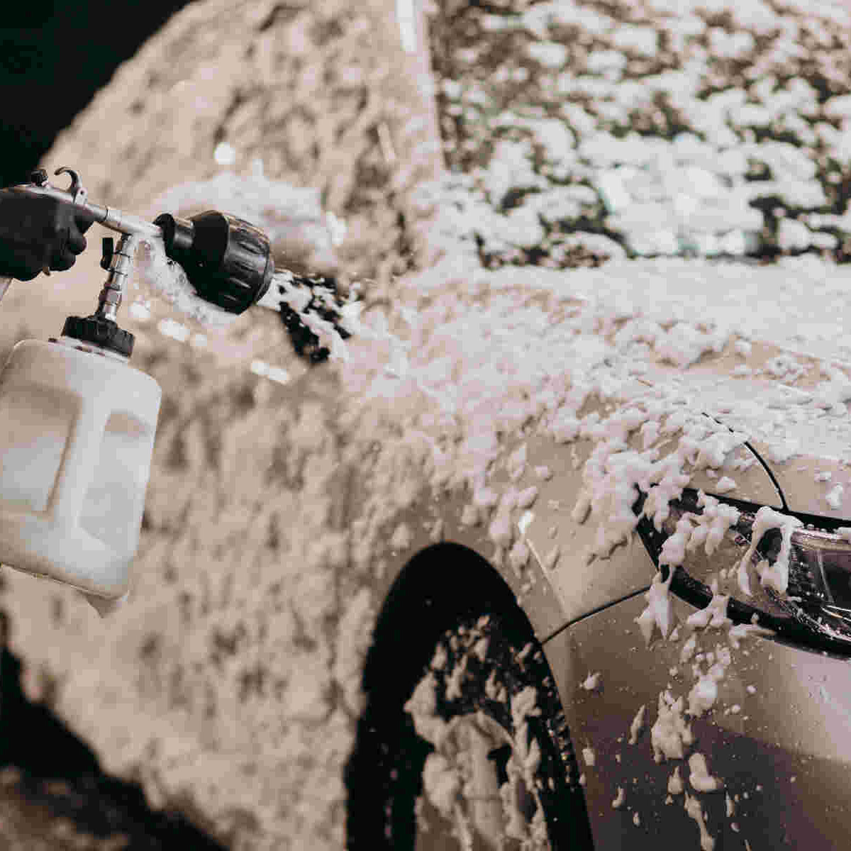A person properly hand washing a car using a microfiber mitt, demonstrating a safe technique to prevent paint damage.